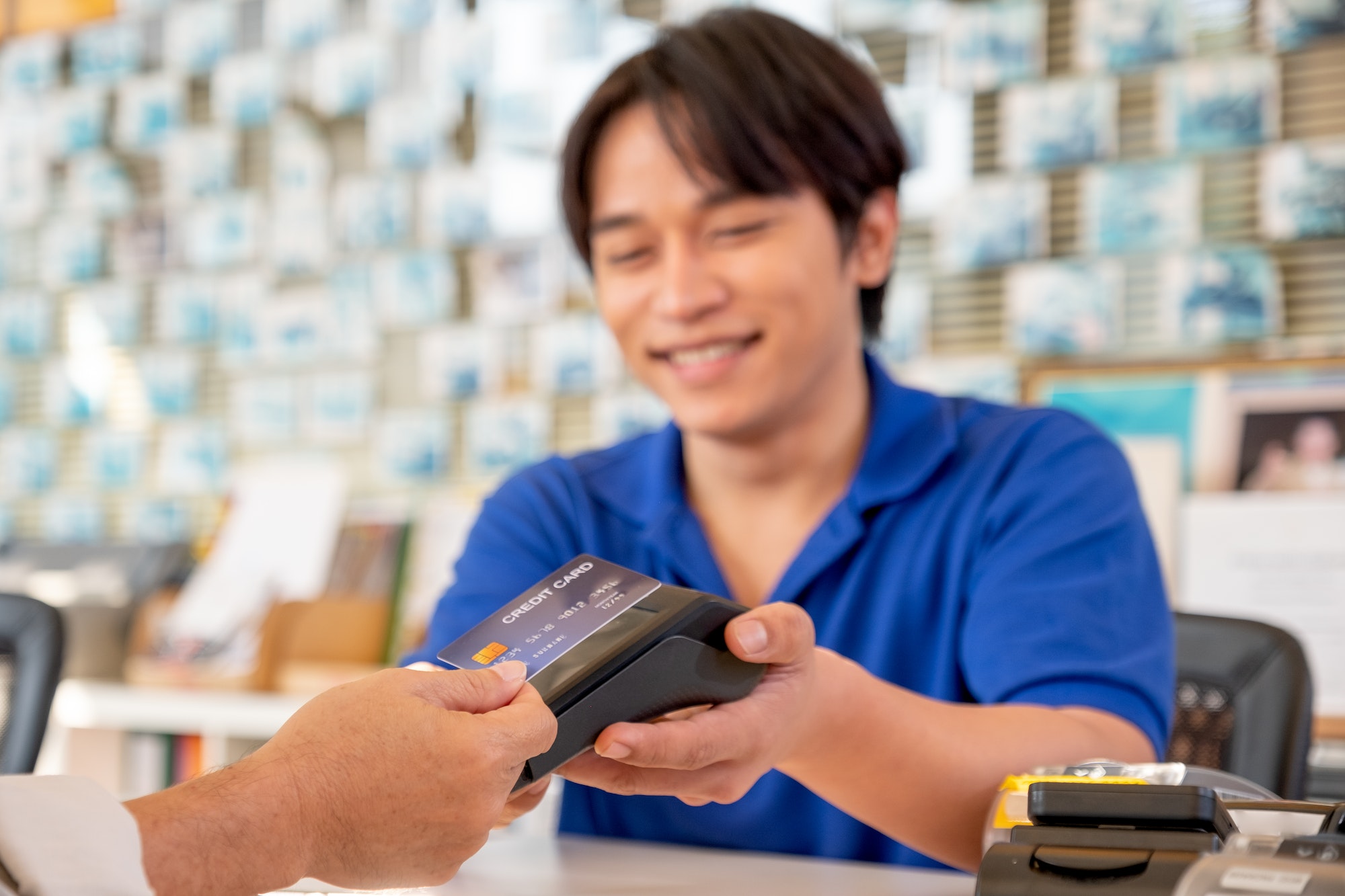 Main focus on credit card of Asian worker or staff at office reception receive credit card